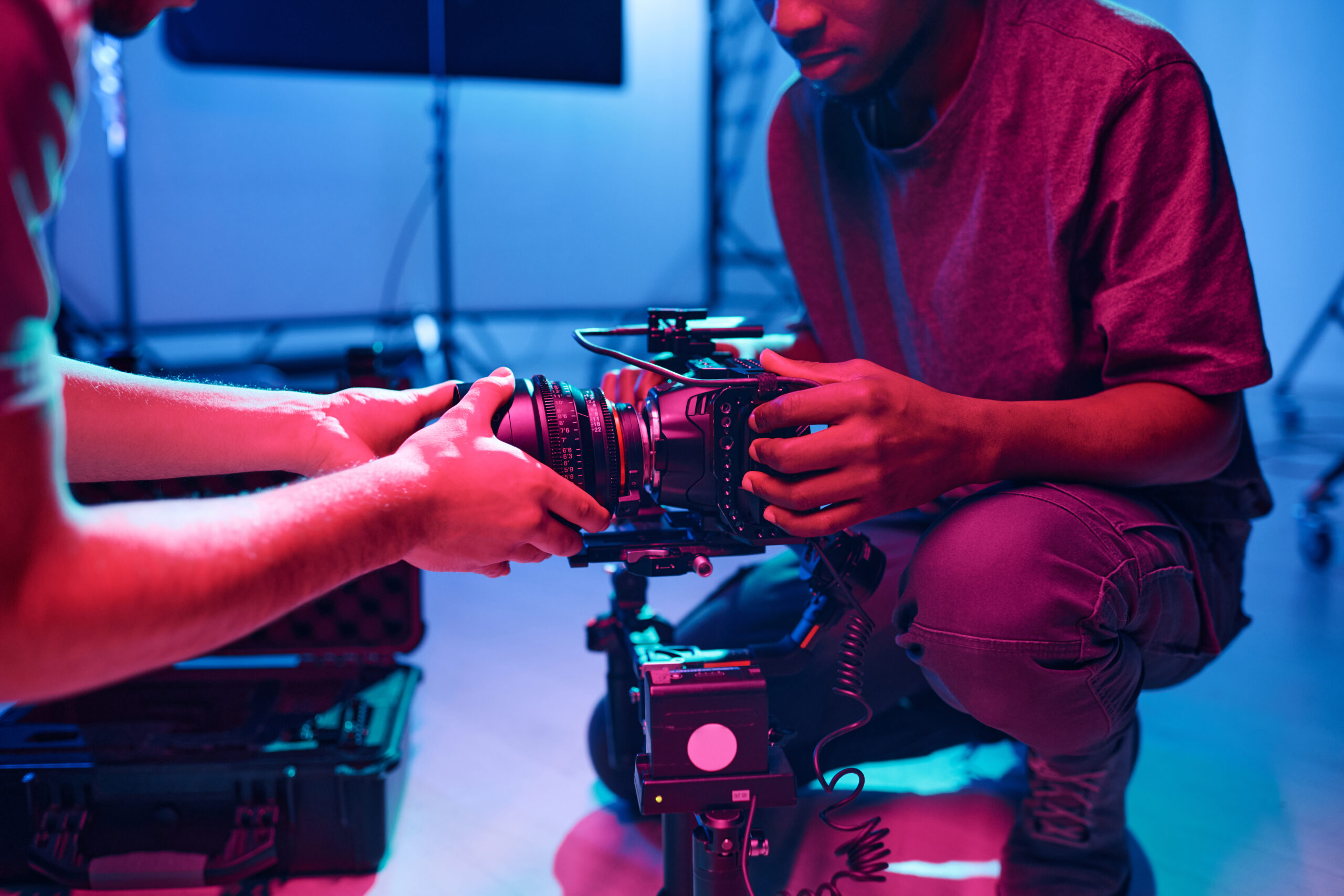 Young operator setting the camera with his assistant before shooting during his work in studio